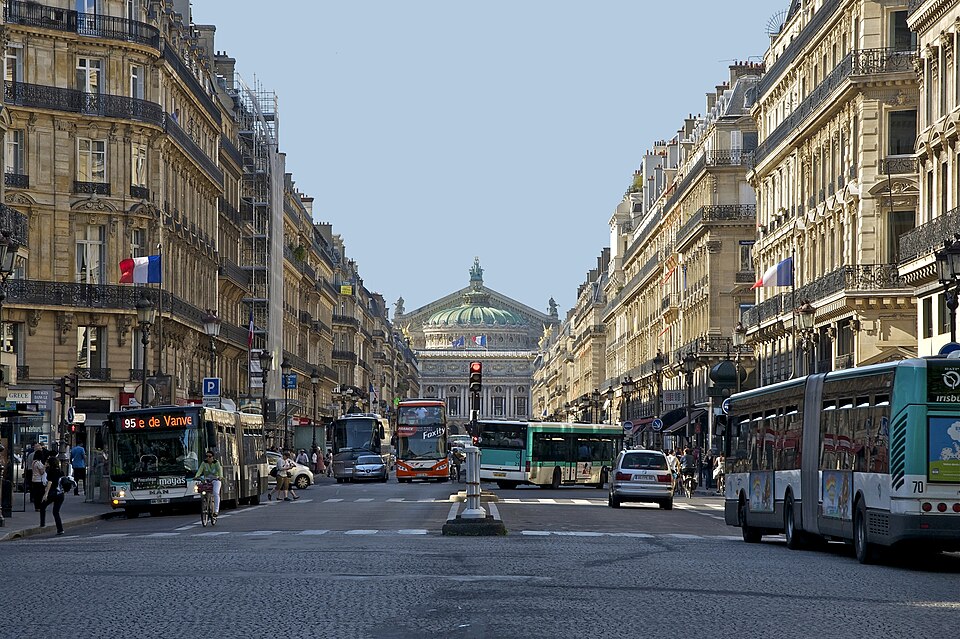 Perspective de l’avenue de l’Opéra bordée d’immeubles haussmanniens et ouverte sur le palais Garnier