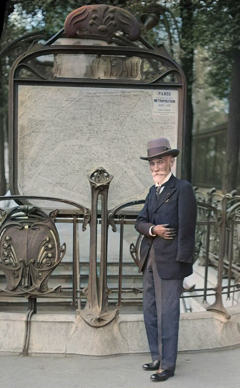 Fulgence Bienvenüe debout devant une entrée du métropolitain parisien